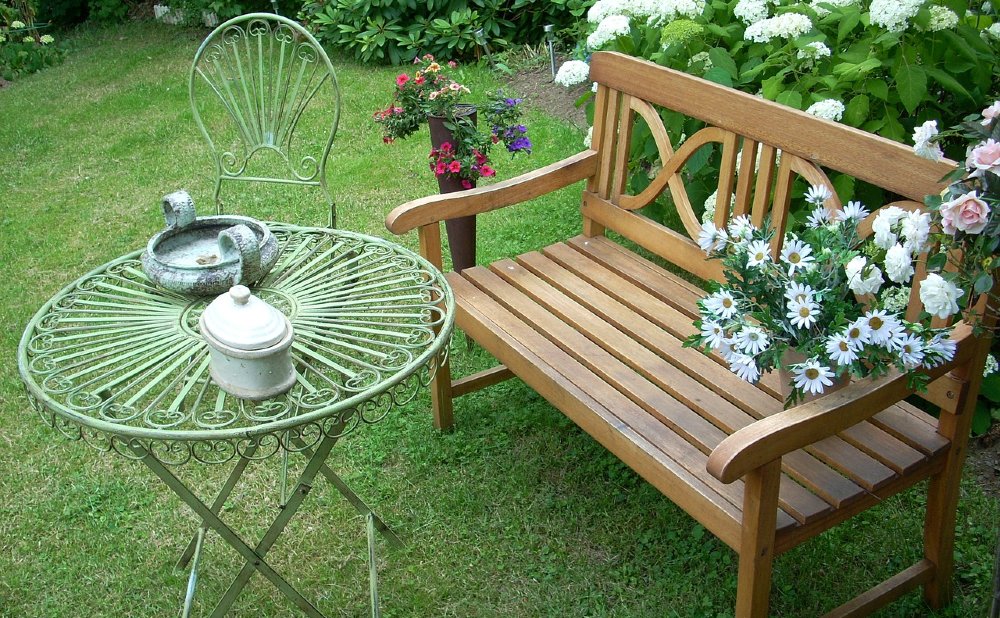 Gartenbank mit Metalltisch und -stuhl